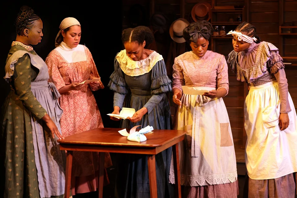 The cast of New Federal Theatre's The Wash gathered around a table